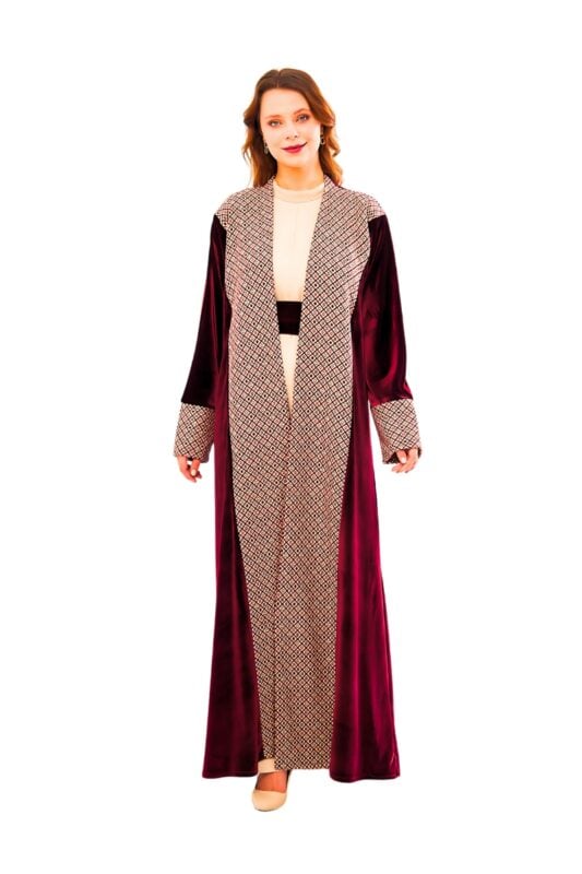 Model wearing the royal ruby mosaic abaya: a long black garment featuring a central mosaic-print panel in cream and ruby tones, contrasted by rich ruby-red velvet side panels and cuffs, with a matching mosaic-print belt.